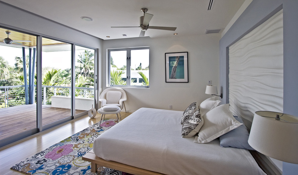 This is an example of a modern bedroom in Miami with multi-coloured walls and medium hardwood floors.