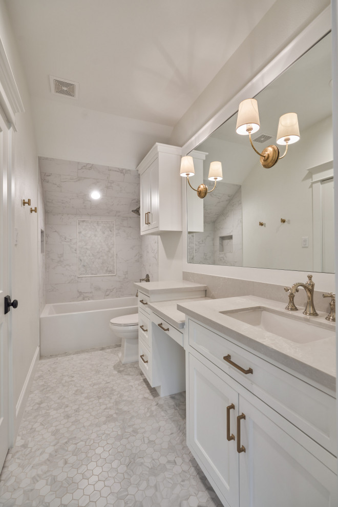 Large french country gray tile and porcelain tile mosaic tile floor, gray floor and single-sink bathroom photo in Houston with recessed-panel cabinets, white cabinets, a one-piece toilet, white walls, an undermount sink, gray countertops and a built-in vanity
