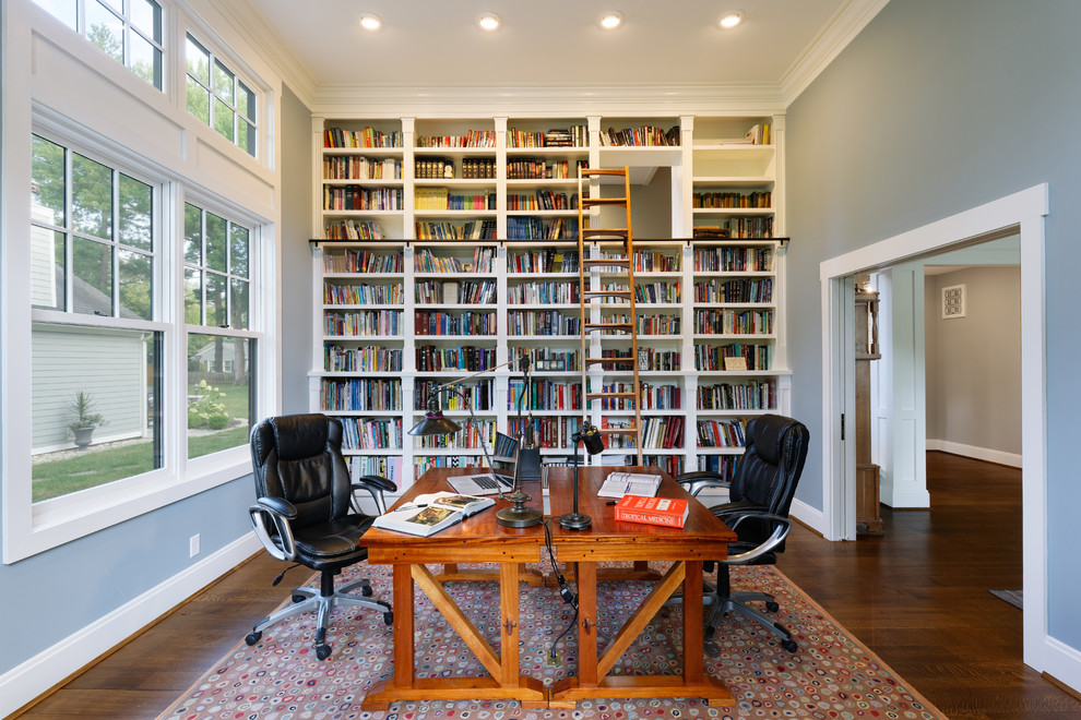 Design ideas for a large traditional home office in Cincinnati with a library, grey walls, a freestanding desk, dark hardwood floors, no fireplace and brown floor.