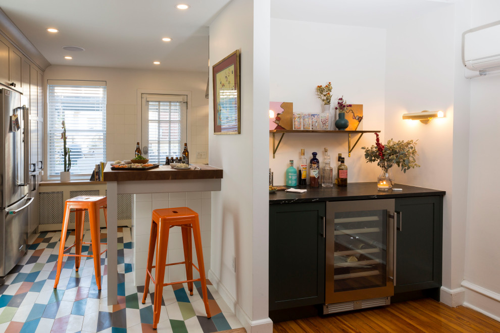 Photo of an eclectic kitchen in Philadelphia with shaker cabinets, grey cabinets, wood benchtops, white splashback, porcelain splashback, coloured appliances, cement tiles, multi-coloured floor and brown benchtop.