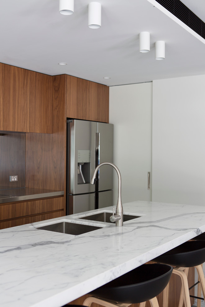 Photo of a large contemporary galley kitchen pantry in Sydney with an undermount sink, marble benchtops, mirror splashback, stainless steel appliances and with island.