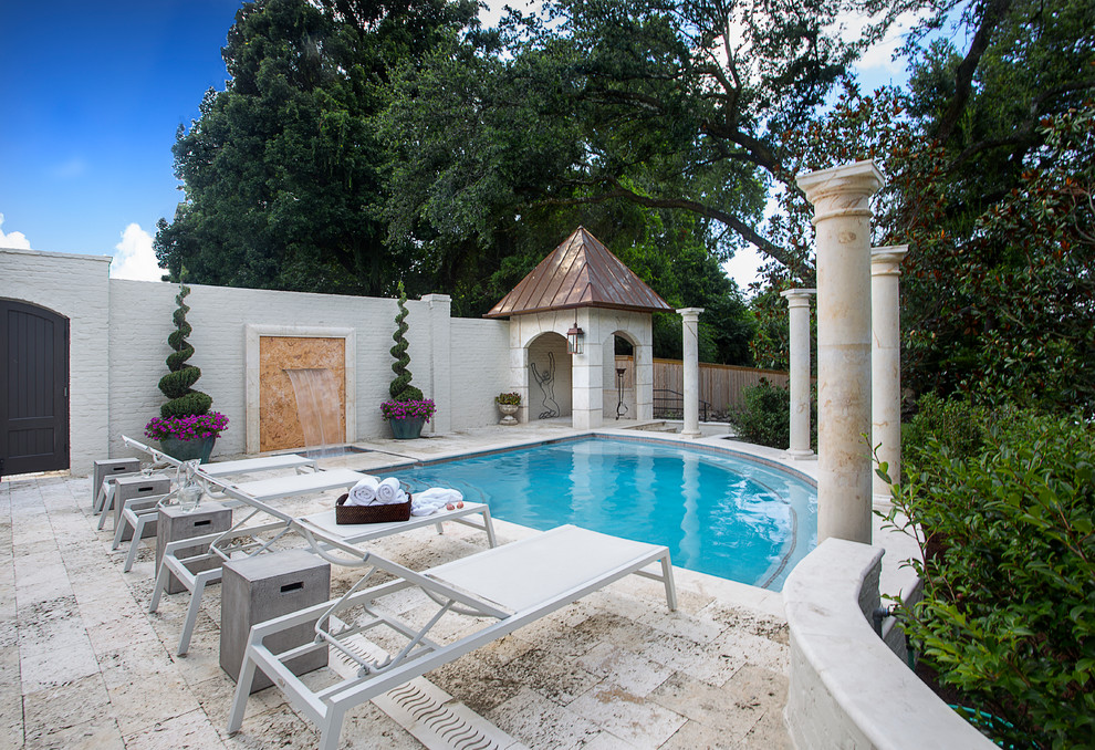 This is an example of a traditional backyard custom-shaped pool in New Orleans with a water feature.