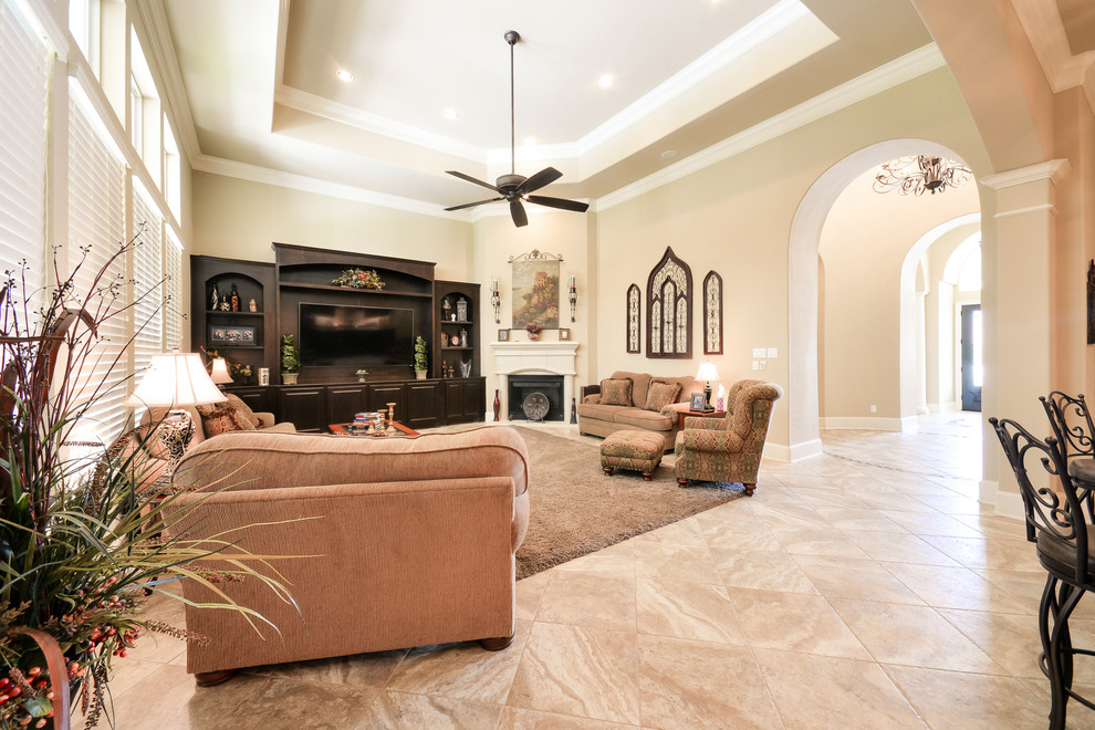 Photo of a mediterranean open concept living room in Houston with beige walls, porcelain floors, a corner fireplace, a stone fireplace surround and a built-in media wall.