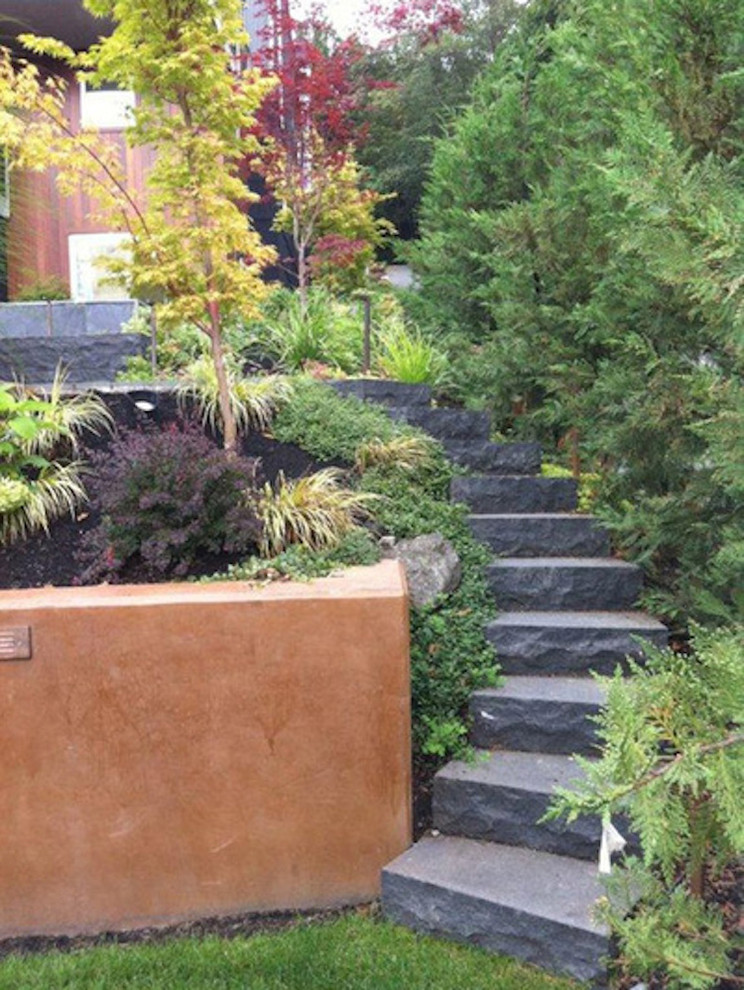 This is an example of a mid-sized traditional front yard full sun formal garden for spring in Seattle with natural stone pavers.