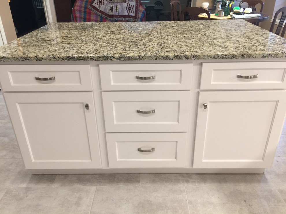 Example of a mid-sized transitional l-shaped porcelain tile eat-in kitchen design in Austin with an undermount sink, shaker cabinets, white cabinets, granite countertops, white backsplash, glass tile backsplash, stainless steel appliances and an island