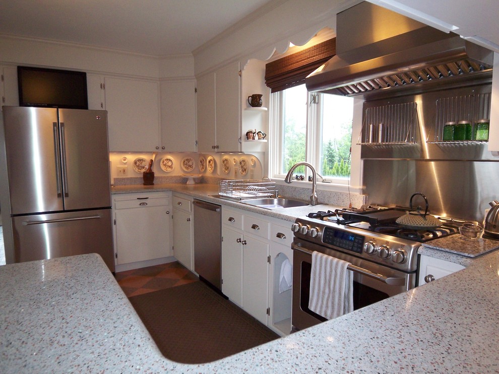 Photo of a traditional u-shaped eat-in kitchen in Boston with a single-bowl sink, flat-panel cabinets, white cabinets, terrazzo benchtops and stainless steel appliances.