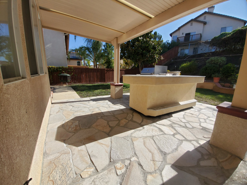 Example of a mid-sized classic backyard stone patio kitchen design in Los Angeles