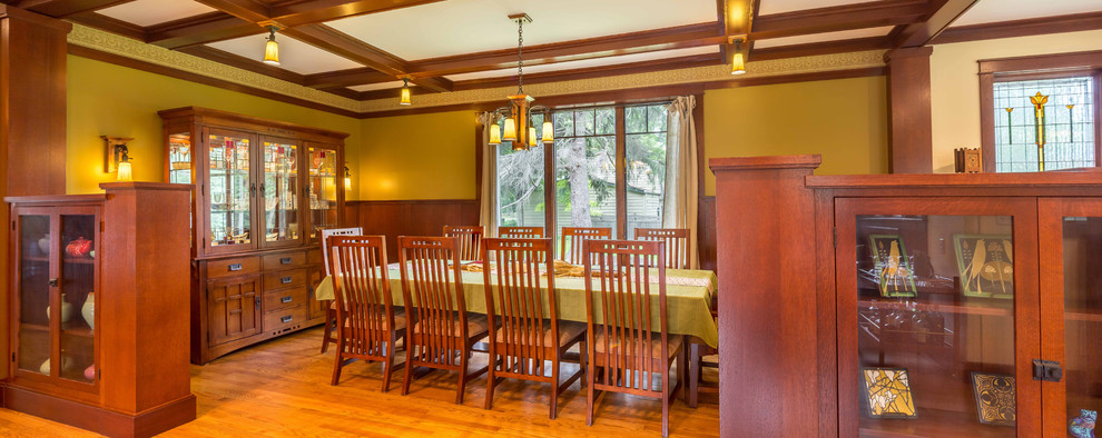 Mid-sized arts and crafts open plan dining in Chicago with yellow walls, light hardwood floors, no fireplace, brown floor, coffered and decorative wall panelling.