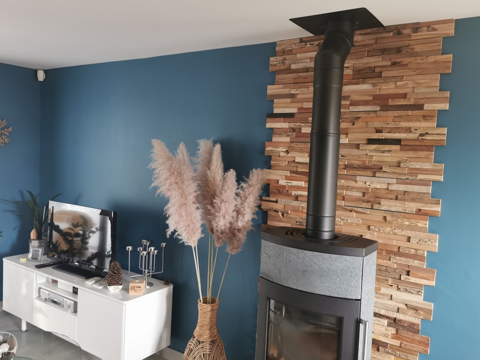 Medium sized modern grey and yellow open plan living room in Clermont-Ferrand with blue walls, ceramic flooring, a wood burning stove and grey floors.