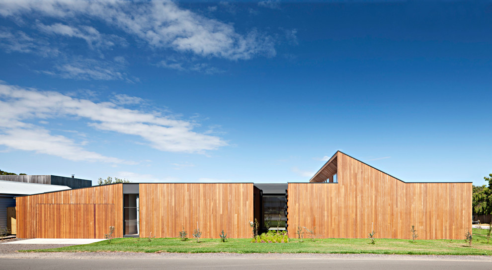 This is an example of a modern one-storey brown house exterior in Geelong with wood siding and a flat roof.