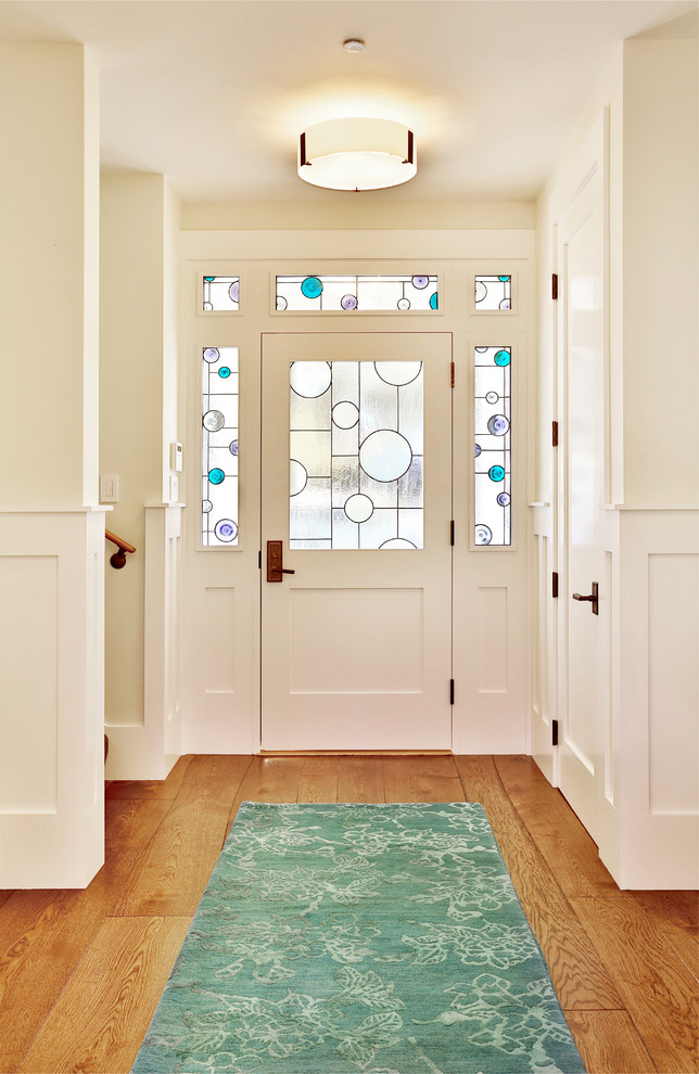 This is an example of a mid-sized transitional foyer in Denver with white walls, medium hardwood floors, a single front door and a glass front door.