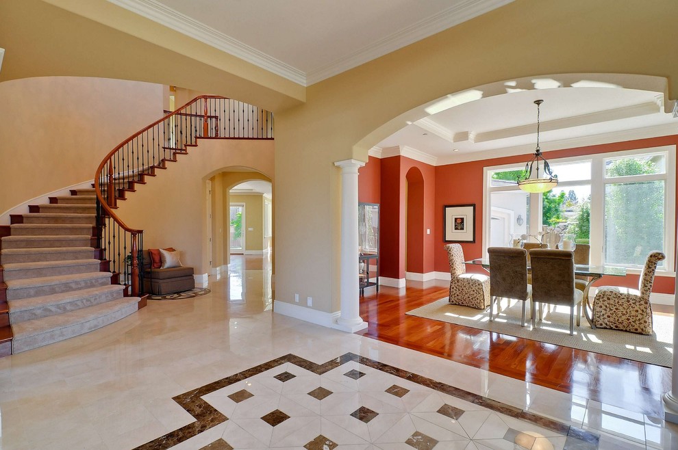 This is an example of a traditional foyer in San Francisco with beige walls, marble floors and beige floor.