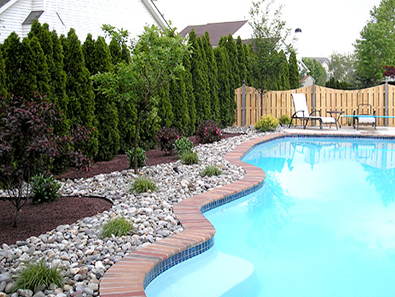 This is an example of a large traditional backyard custom-shaped lap pool in Philadelphia with concrete slab.