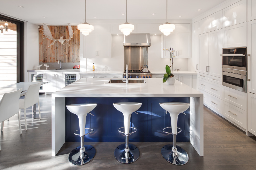 Large transitional l-shaped dark wood floor eat-in kitchen photo in Toronto with an undermount sink, shaker cabinets, white cabinets, quartz countertops, white backsplash, stainless steel appliances and an island