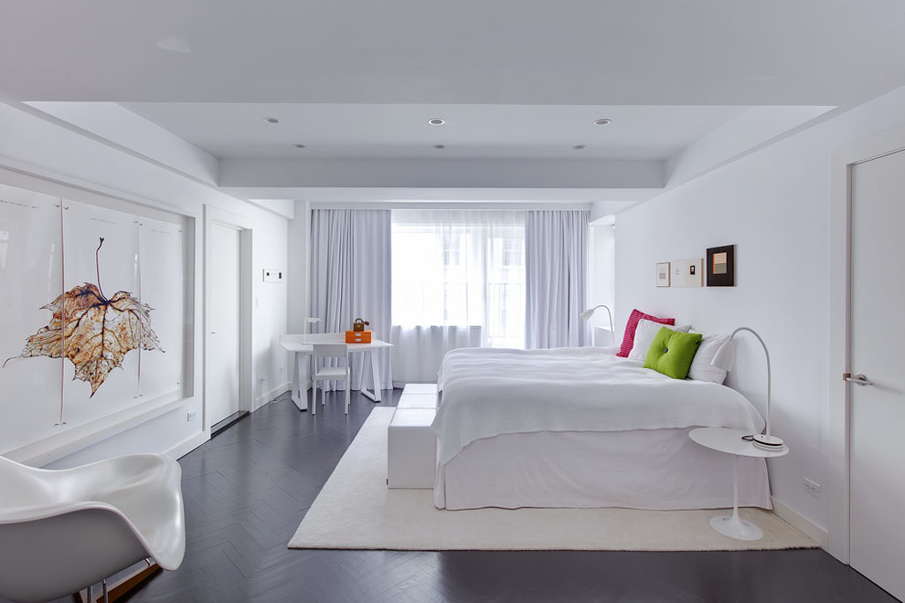 Large contemporary bedroom in New York with white walls and dark hardwood floors.