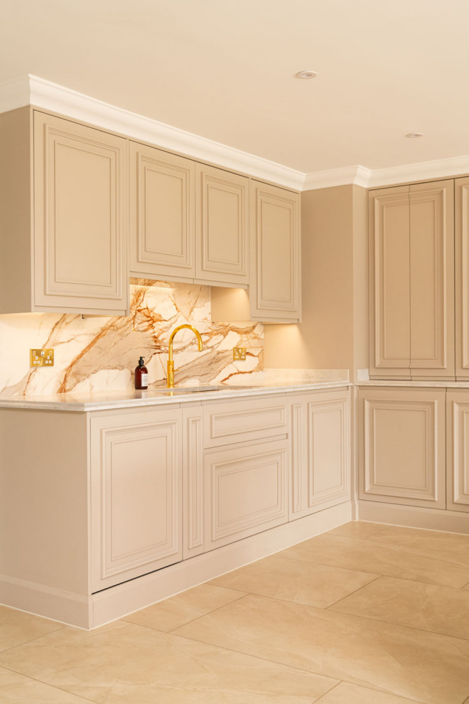 Modern inredning av ett mycket stort vit vitt kök, med en dubbel diskho, skåp i shakerstil, grå skåp, bänkskiva i kvartsit, orange stänkskydd, stänkskydd i porslinskakel, rostfria vitvaror, travertin golv, en köksö och brunt golv