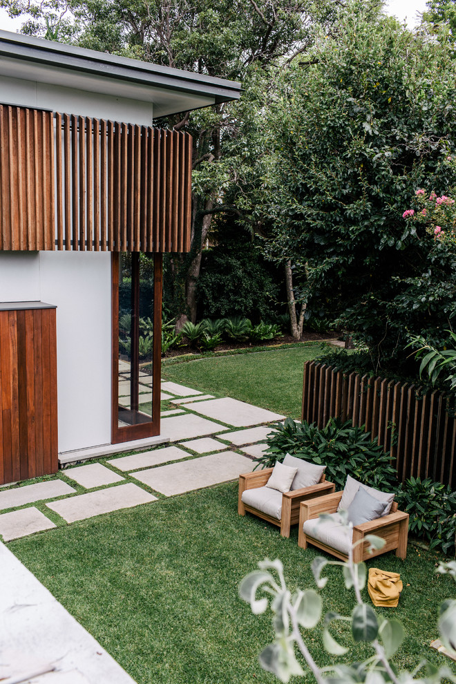 Expansive modern backyard partial sun garden in Sydney with a retaining wall for summer.