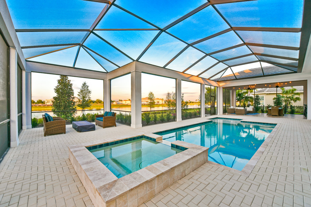 Photo of a large contemporary indoor rectangular lap pool in Tampa with brick pavers.