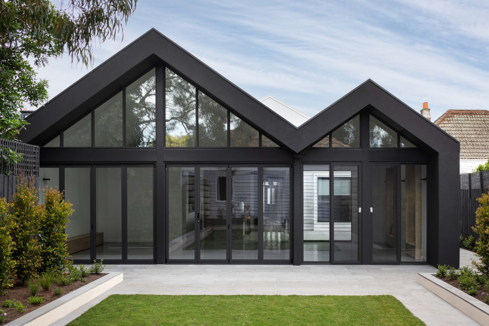 This is an example of a one-storey black house exterior in Melbourne with a black roof.