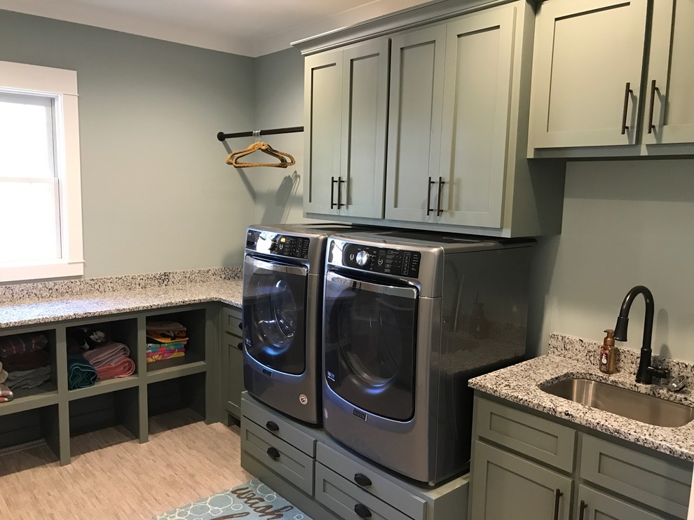 Design ideas for a mid-sized transitional dedicated laundry room in Raleigh with shaker cabinets, grey cabinets, granite benchtops, grey walls, vinyl floors, a side-by-side washer and dryer and beige floor.