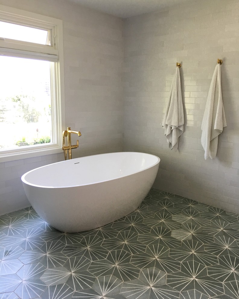 Large contemporary master bathroom in Los Angeles with flat-panel cabinets, dark wood cabinets, a freestanding tub, an open shower, a one-piece toilet, white tile, ceramic tile, white walls, cement tiles, marble benchtops, green floor and an open shower.