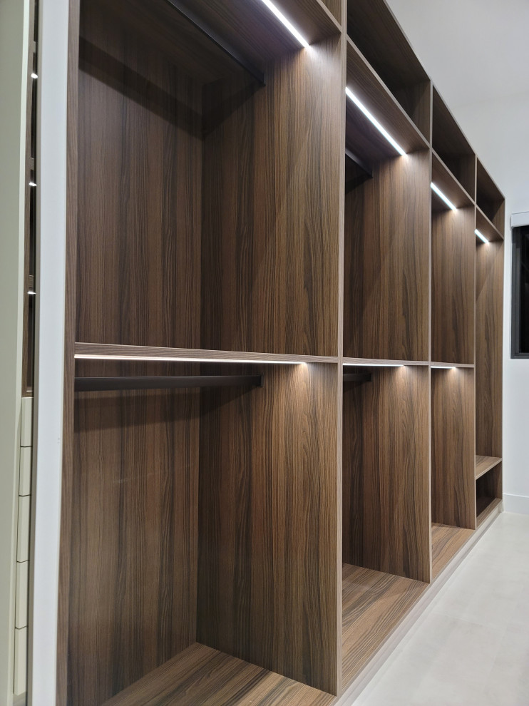 This is an example of a large contemporary gender-neutral walk-in wardrobe in Miami with open cabinets, dark wood cabinets, ceramic floors and grey floor.