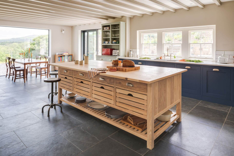 This is an example of a large country l-shaped open plan kitchen in Other with shaker cabinets, blue cabinets and with island.