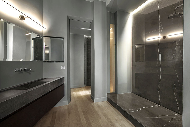 Photo of a modern 3/4 bathroom in Other with brown cabinets, an open shower, gray tile, grey walls, light hardwood floors, marble benchtops, brown floor, brown benchtops, a niche, a single vanity and a floating vanity.