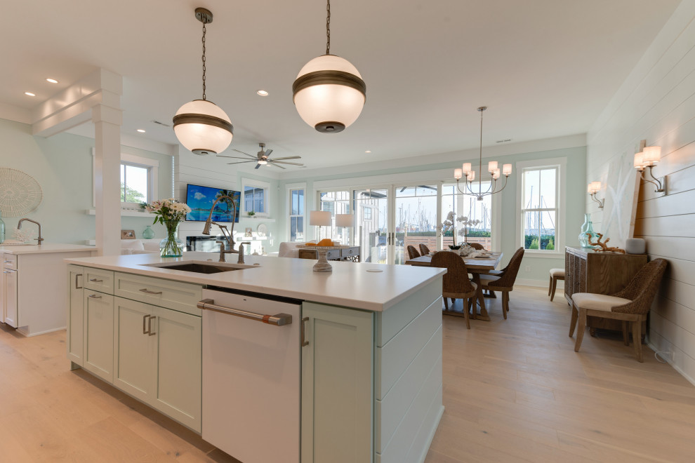 Large country galley open plan kitchen in Other with a single-bowl sink, shaker cabinets, white cabinets, quartz benchtops, green splashback, glass tile splashback, white appliances, light hardwood floors, multiple islands, grey floor and white benchtop.