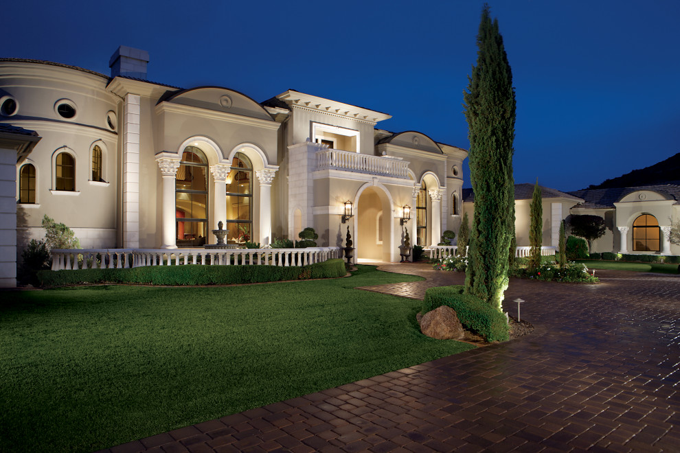 Immagine della villa ampia grigia mediterranea a due piani con rivestimento in stucco, tetto a padiglione, copertura mista e tetto grigio