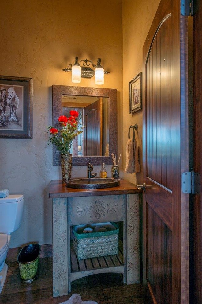 This is an example of a mid-sized country bathroom in Other with a drop-in sink, open cabinets, beige walls, dark hardwood floors, wood benchtops and brown benchtops.