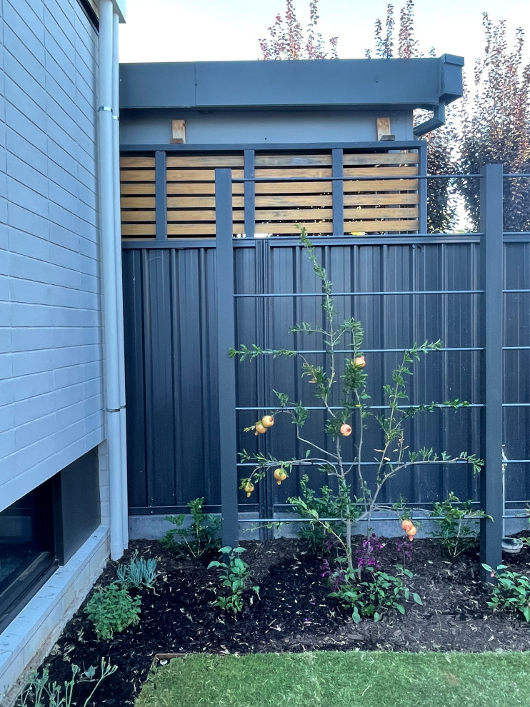Idéer för en liten modern trädgård i full sol som tål torka och framför huset på våren, med marksten i tegel