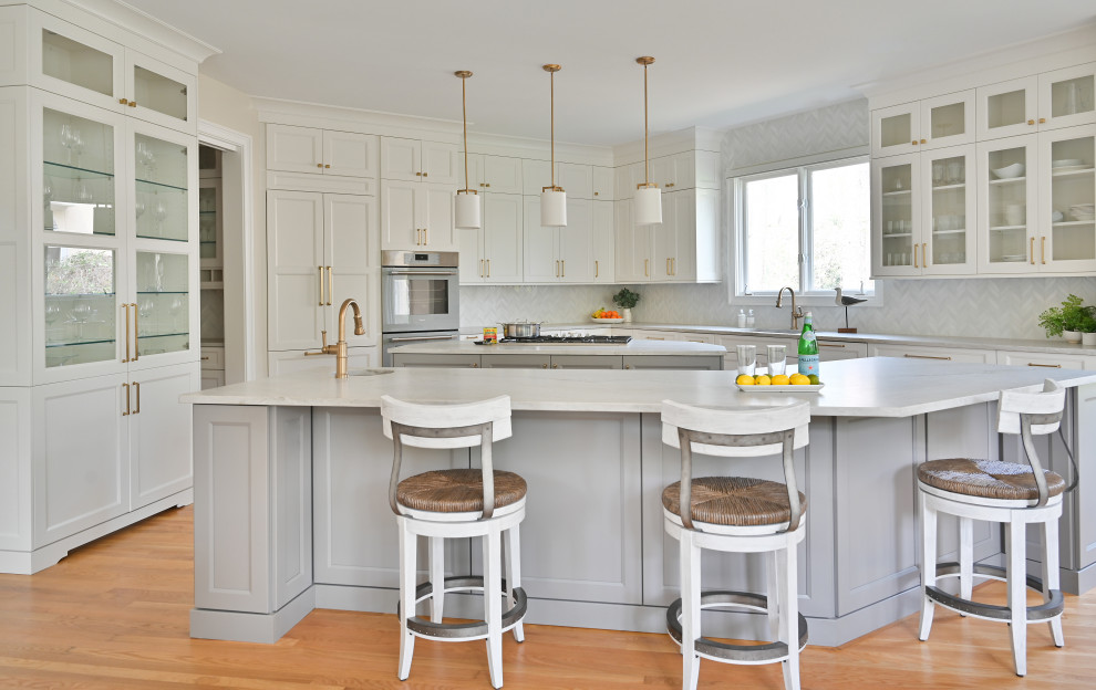 Eat-in kitchen - transitional light wood floor and brown floor eat-in kitchen idea in Atlanta with an undermount sink, recessed-panel cabinets, white cabinets, gray backsplash, paneled appliances, two islands and gray countertops