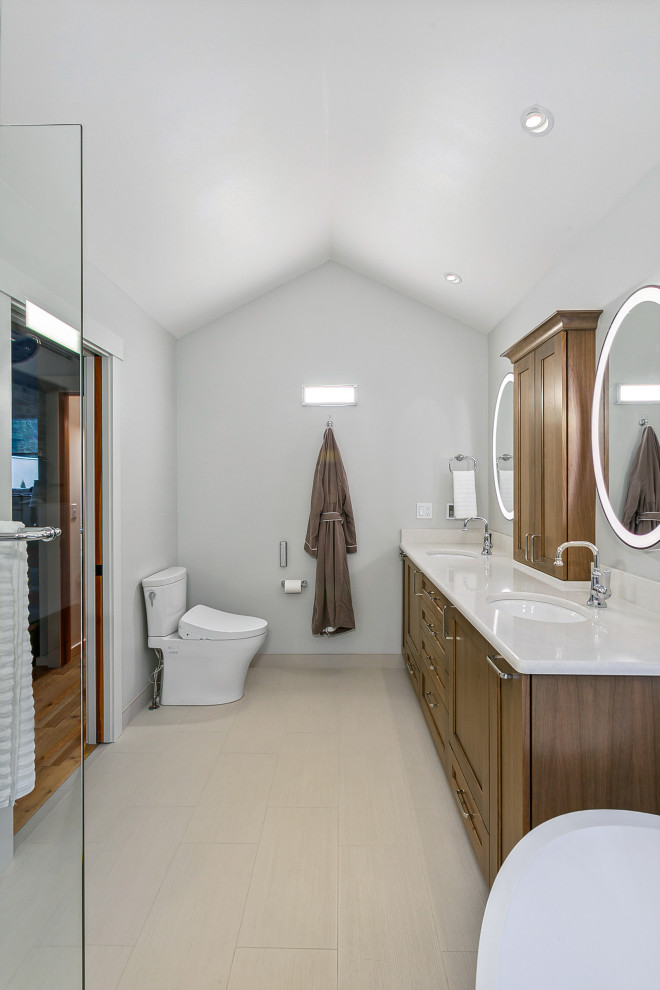 This is an example of a large contemporary master wet room bathroom in Seattle with recessed-panel cabinets, brown cabinets, a freestanding tub, a bidet, blue tile, porcelain tile, white walls, ceramic floors, an undermount sink, engineered quartz benchtops, beige floor, an open shower, a shower seat, a double vanity, a built-in vanity, vaulted and white benchtops.
