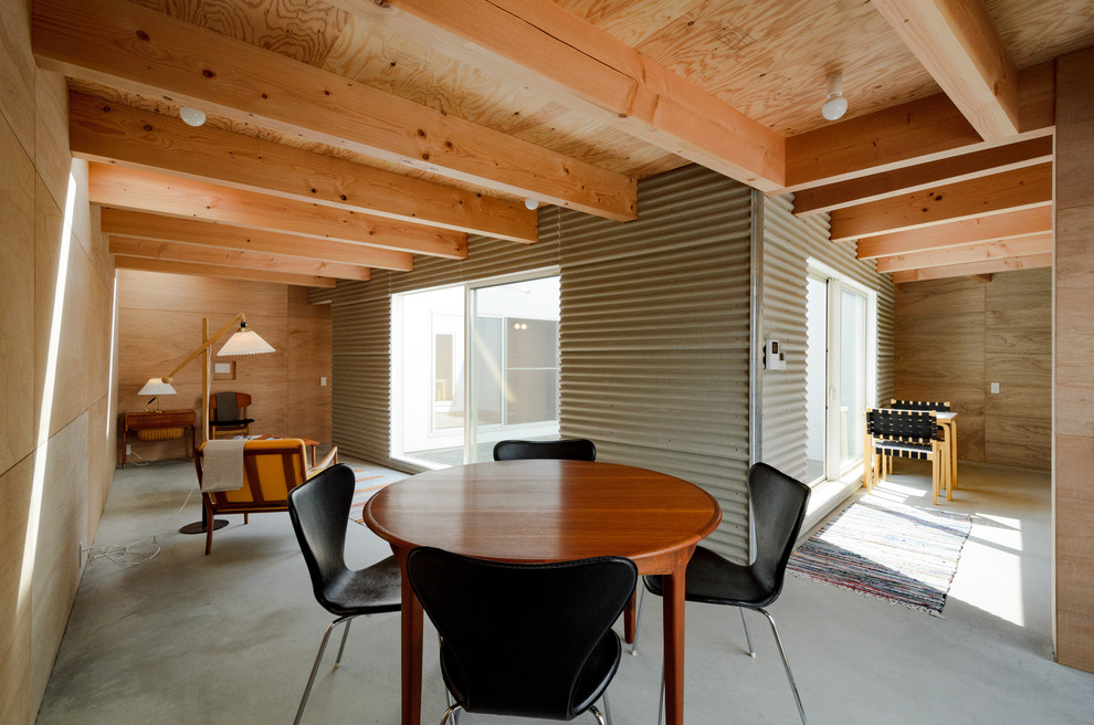 This is an example of an industrial dining room in Other with brown walls, concrete floors and grey floor.