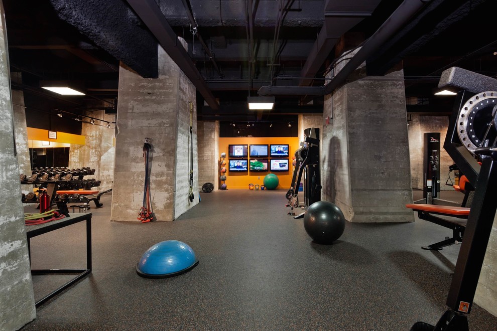 Inspiration for a large industrial multipurpose gym in Baltimore with orange walls, cork floors and black floor.