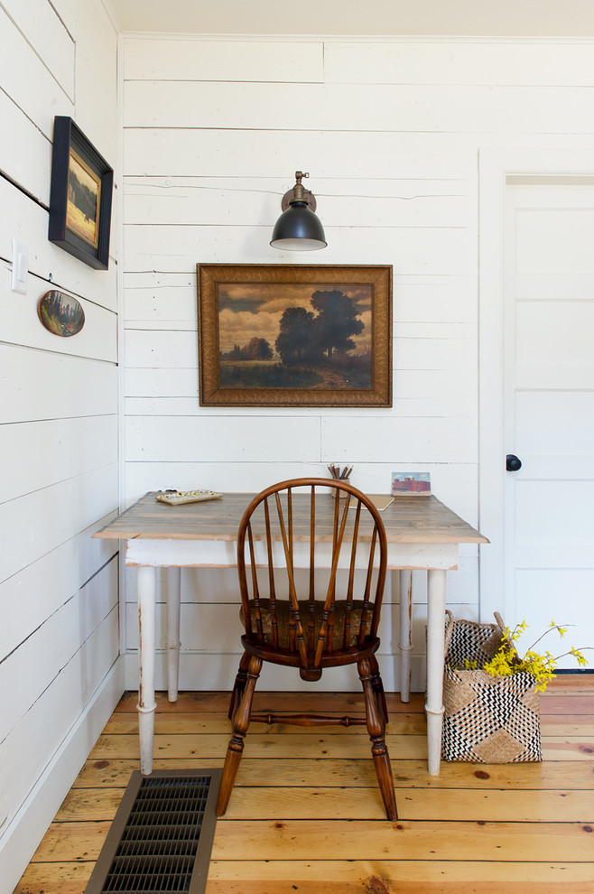This is an example of a traditional home office in Other with white walls, medium hardwood floors and a freestanding desk.