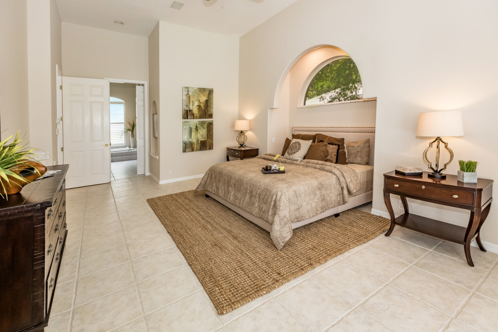 Inspiration for a large mediterranean master bedroom in Tampa with beige walls, porcelain floors and beige floor.