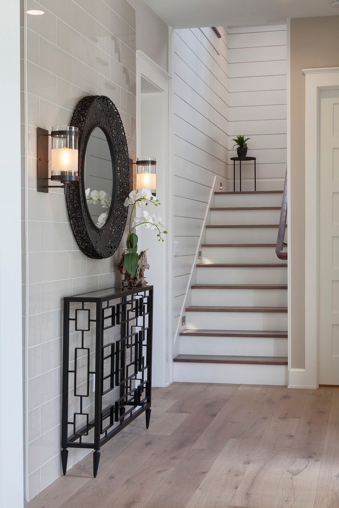 Example of a mid-sized transitional light wood floor foyer design in Orlando with beige walls and a black front door