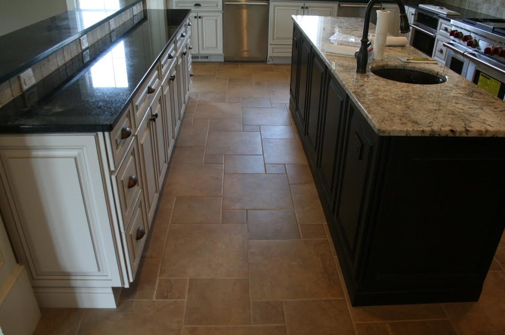 Kitchen - large transitional travertine floor and brown floor kitchen idea with an undermount sink, beaded inset cabinets, white cabinets, granite countertops, beige backsplash, ceramic backsplash, stainless steel appliances and two islands