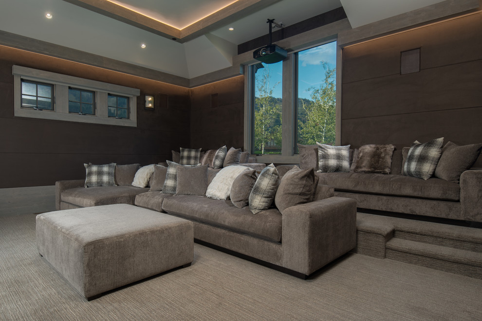 This is an example of a modern enclosed home theatre in Other with brown walls, carpet and a projector screen.