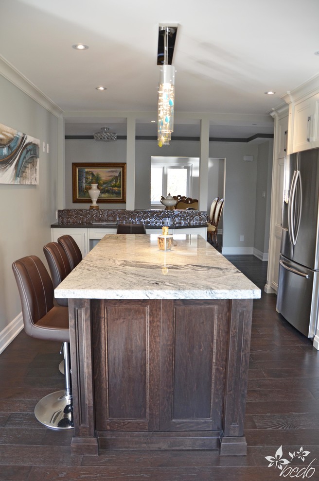Mid-sized transitional l-shaped dark wood floor home design photo in Toronto with a double-bowl sink, shaker cabinets, white cabinets, quartz countertops, brown backsplash, mosaic tile backsplash, stainless steel appliances and an island