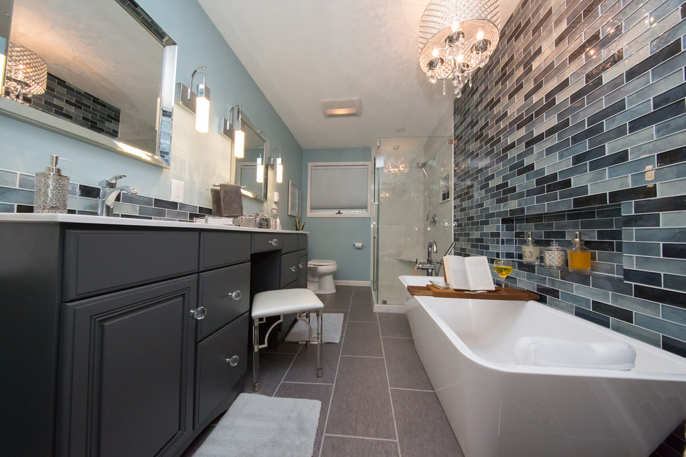 Design ideas for a mid-sized modern master bathroom in Other with raised-panel cabinets, grey cabinets, a freestanding tub, a corner shower, a bidet, blue tile, glass sheet wall, blue walls, an integrated sink, marble benchtops, grey floor and a sliding shower screen.