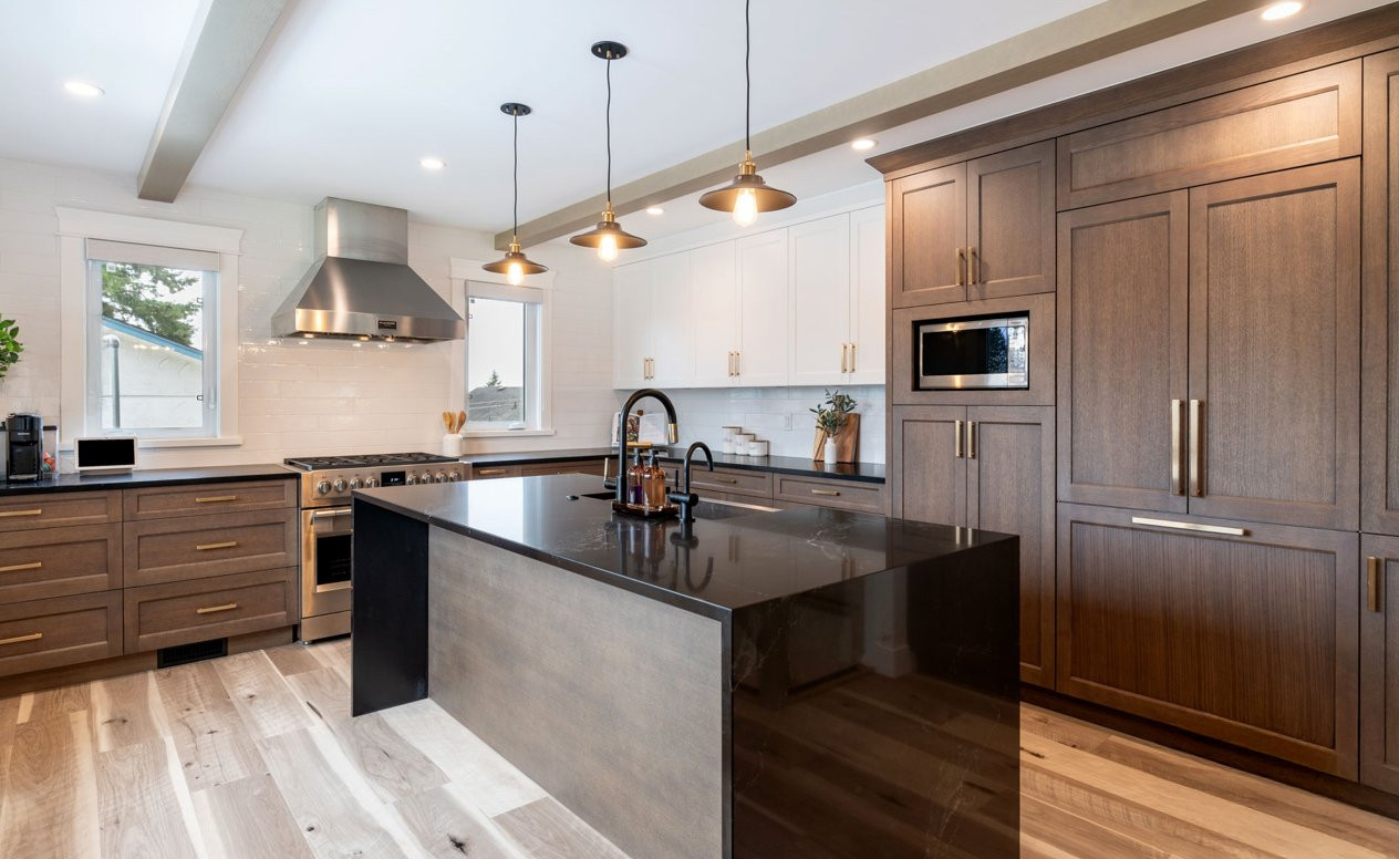 This open-concept kitchen remodel blends warmth and contrast through custom wood cabinetry, crisp white uppers, and matte black quartz countertops. LuxeRevive fabricated full-overlay shaker cabinetry