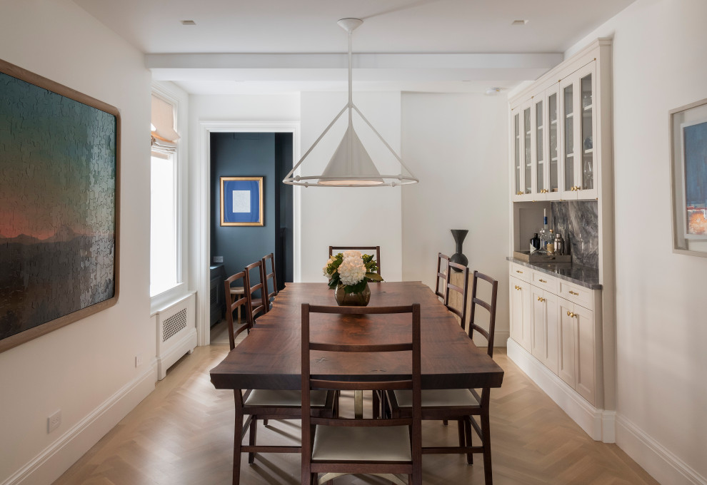 Example of a transitional light wood floor and beige floor dining room design in New York with white walls