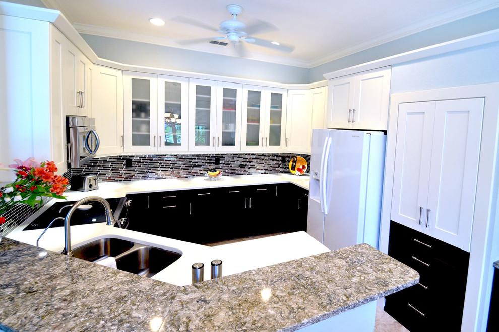 Inspiration for a large transitional u-shaped ceramic tile eat-in kitchen remodel in Miami with an undermount sink, shaker cabinets, white cabinets, quartzite countertops, multicolored backsplash, glass tile backsplash, white appliances and blue walls