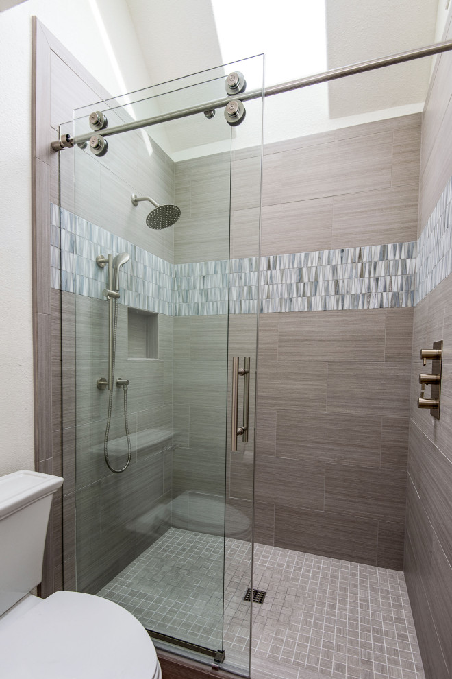 Inspiration for a mid-sized master bathroom in Portland with an alcove shower, a sliding shower screen, beige tile, stone tile, beige walls, mosaic tile floors and beige floor.