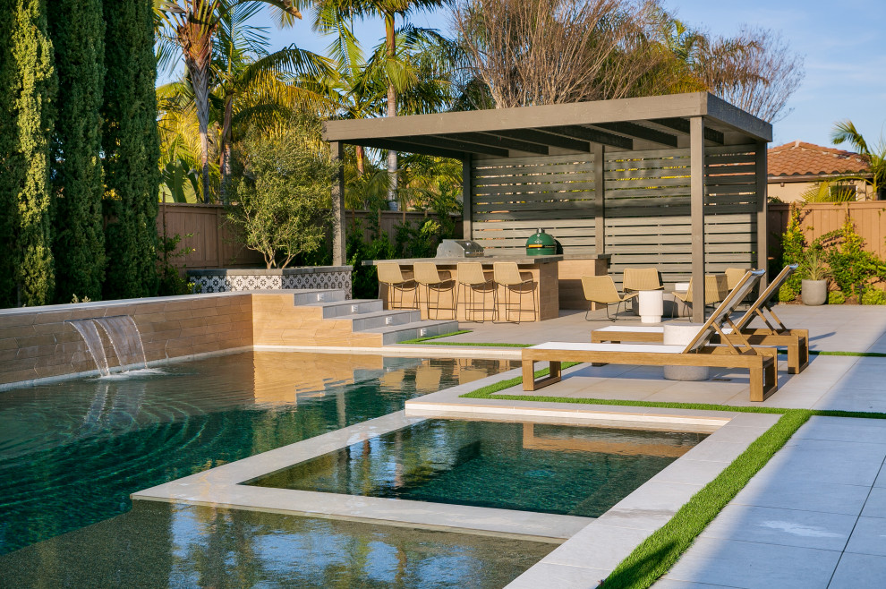 Cette photo montre un grand piscine avec aménagement paysager arrière chic rectangle avec du carrelage.