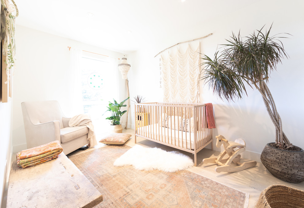 Idee per una piccola cameretta per neonati neutra nordica con pareti bianche, parquet chiaro e pavimento beige