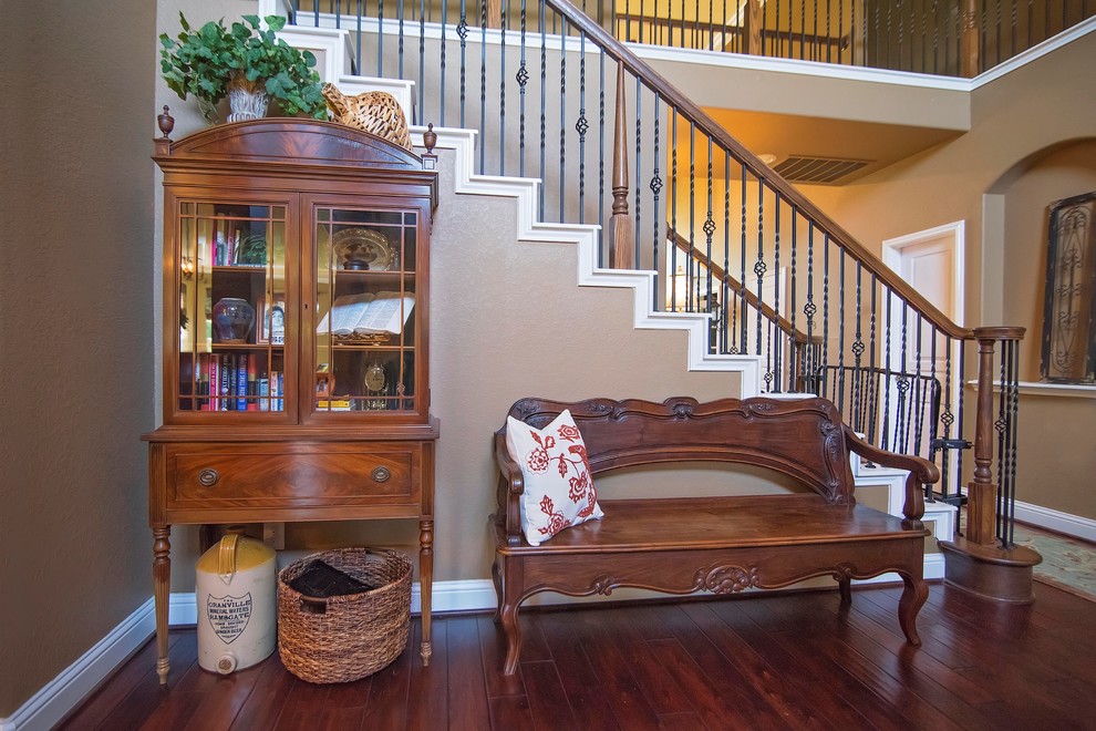 Foyer - mid-sized traditional dark wood floor and brown floor foyer idea in Houston with beige walls